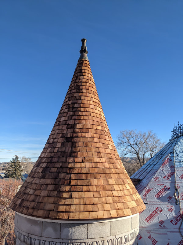 Spire on a historic building, covered in new shingles